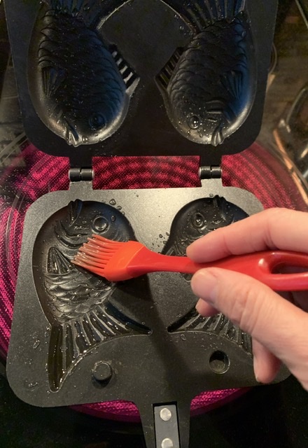Brushing oil onto the taiyaki pan