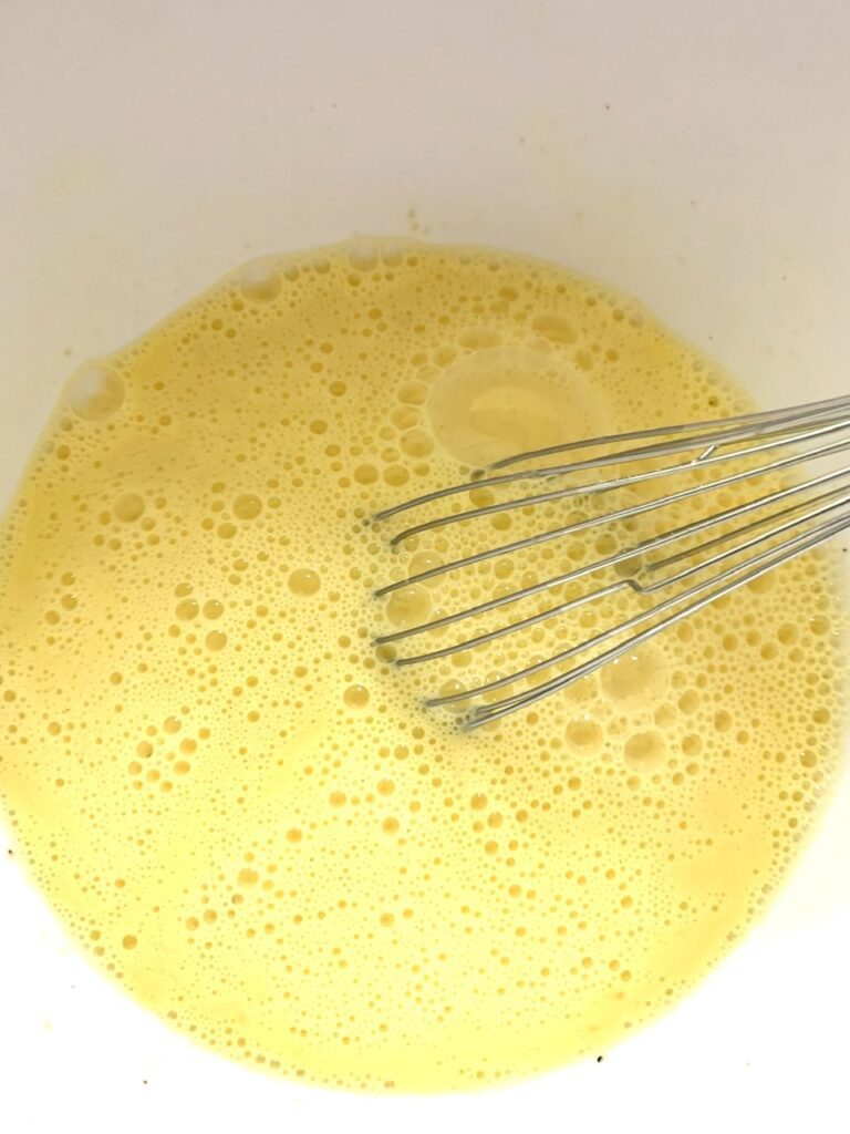 Whisk together the eggs, milk, garlic, salt and pepper